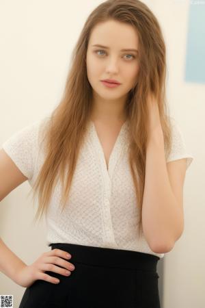A woman in a black blazer and white shirt posing for a picture.