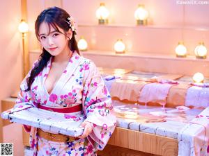A woman in a pink kimono posing for the camera.