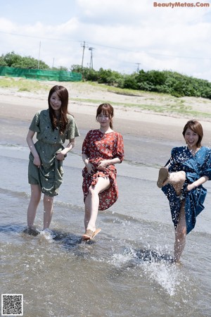 A group of naked women walking down a dirt road.