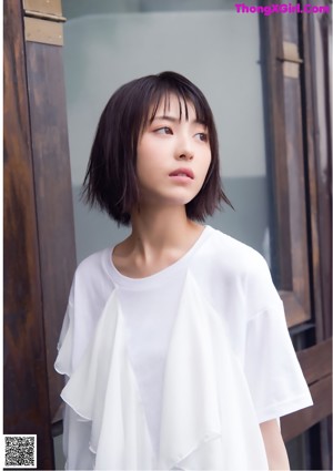 A woman in a white shirt and black skirt posing for a picture.