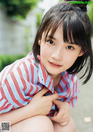 A woman in a school uniform sitting on a bench.