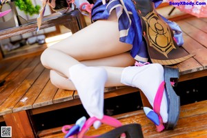 A woman sitting on a wooden bench with her legs crossed.