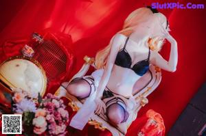 A woman in lingerie posing on a chair.