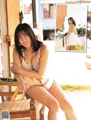 A woman in a blue lingerie leaning against a window.