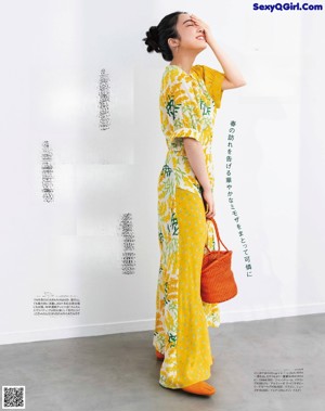 A woman in a blue and white dress is posing for a magazine.