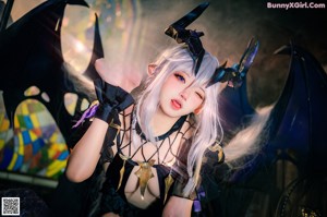 A woman in a black dress sitting on a chair.