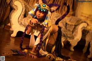 A woman dressed as an egyptian goddess holding a sword.