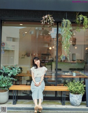 A woman in a green dress holding a book.