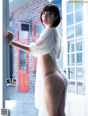 A woman in a polka dot bikini sitting on a stool.