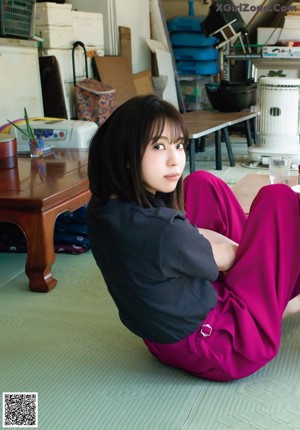 A woman sitting on the floor in front of a table.