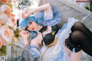 A woman with blue hair is posing on a couch.