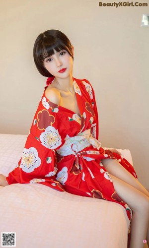 A woman in a red kimono laying on a table.