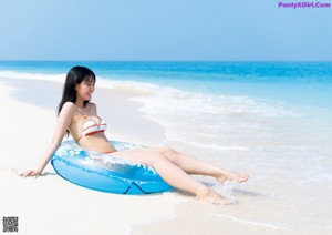 A woman in a white tank top posing for a picture.