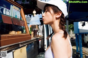 A woman in a bikini holding a cup of ice cream.