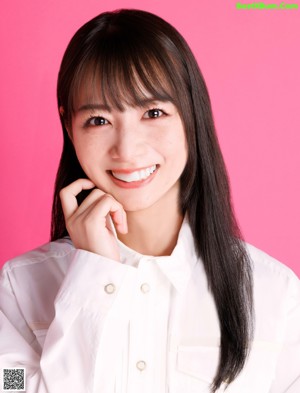 A woman in a white shirt is posing for a magazine.