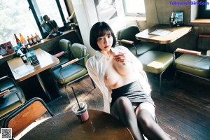 A woman sitting at a bar with her legs crossed.