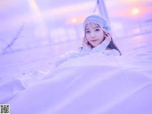 a woman in a pink top and white shorts on a bed