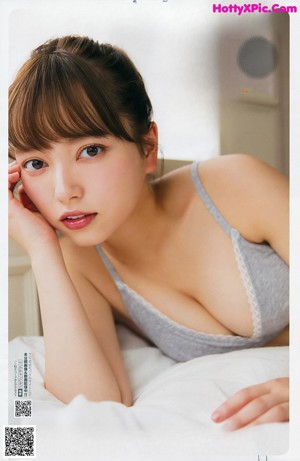 A woman in a white and orange bikini posing for a magazine.