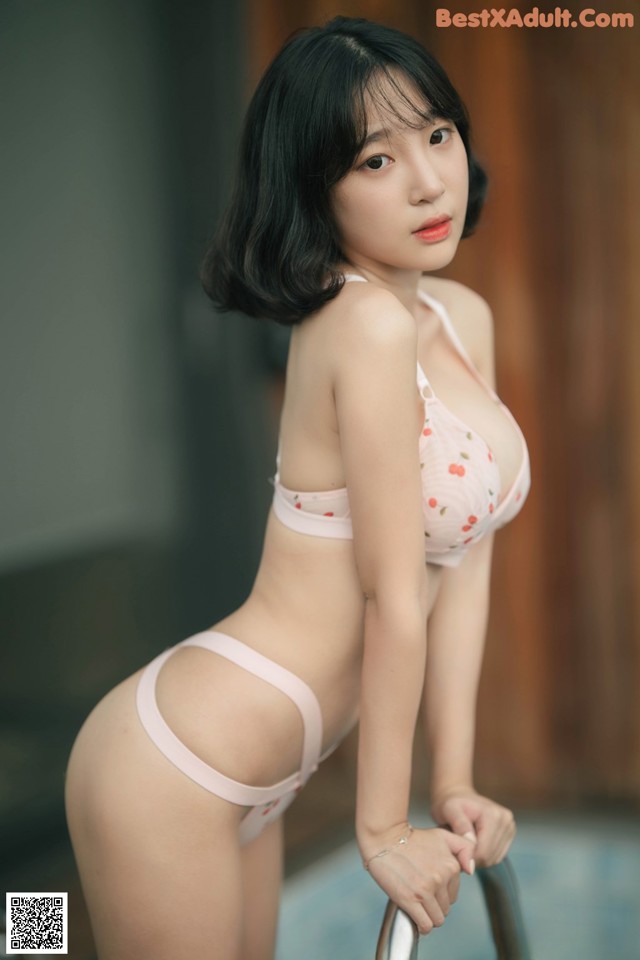 A woman in a pink bikini posing for a picture.
