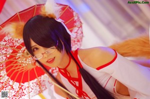 A woman in a white and red outfit is posing on a bed.